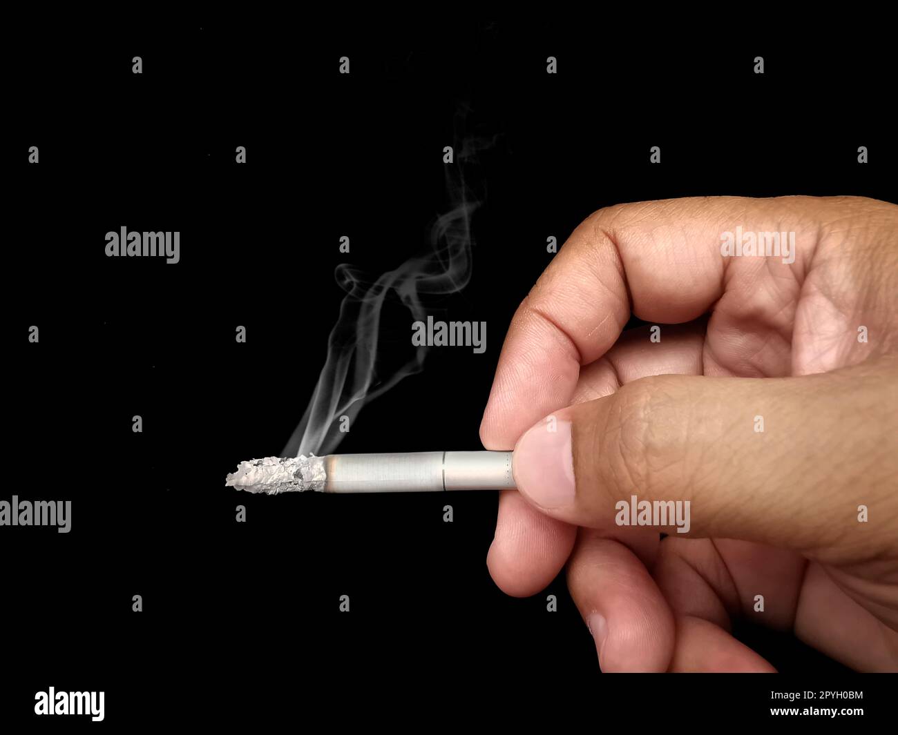Schließen Sie die Hand eines Mannes mit einer zerkrümmerten, schwelenden Zigarette mit rauchender Hand Rauchen Zigarette, ungesunde Lebensweise Konzept Stockfoto