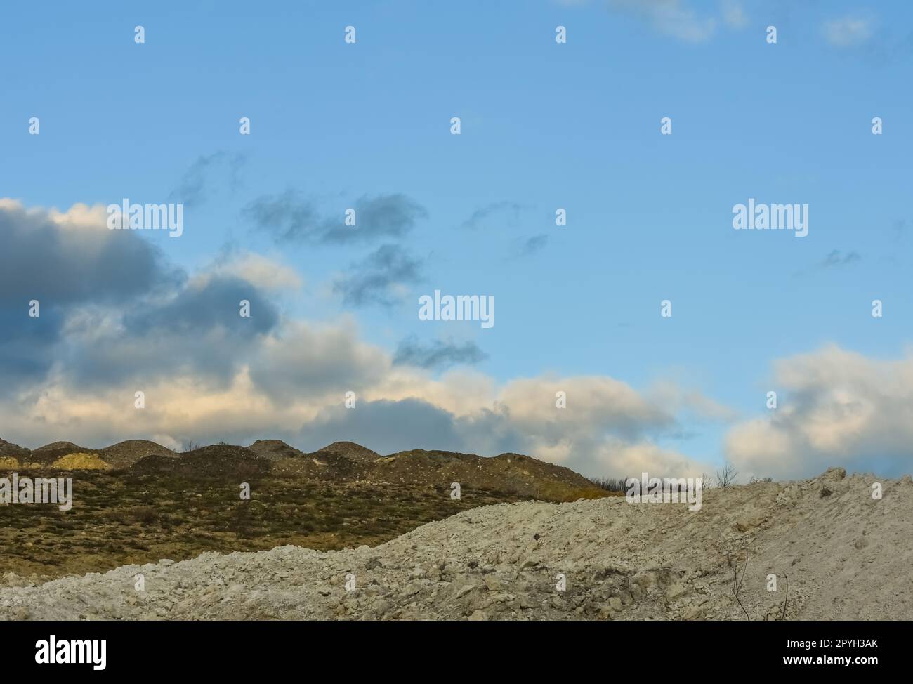 Hügel in einem Kalksteinbruch mit Wolken am blauen Himmel Stockfoto