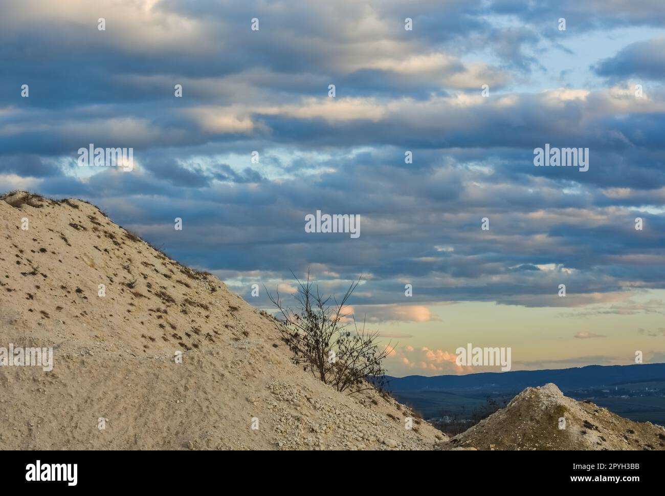 Hügel aus einem Kalksteinbruch und Regenwolken am Himmel Stockfoto