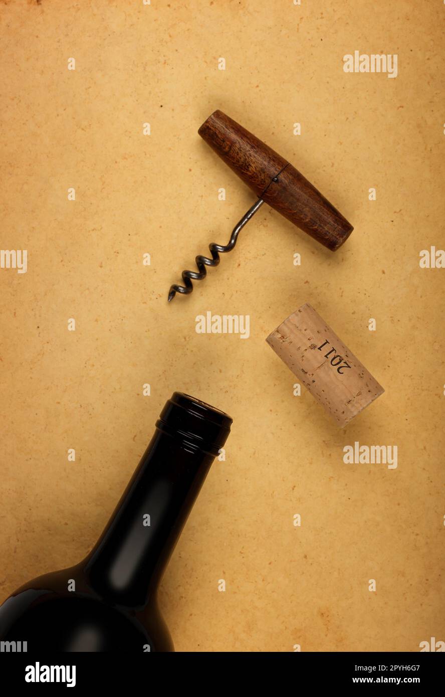 Flasche Wein mit Kork und Öffner auf braunem Papier Stockfoto