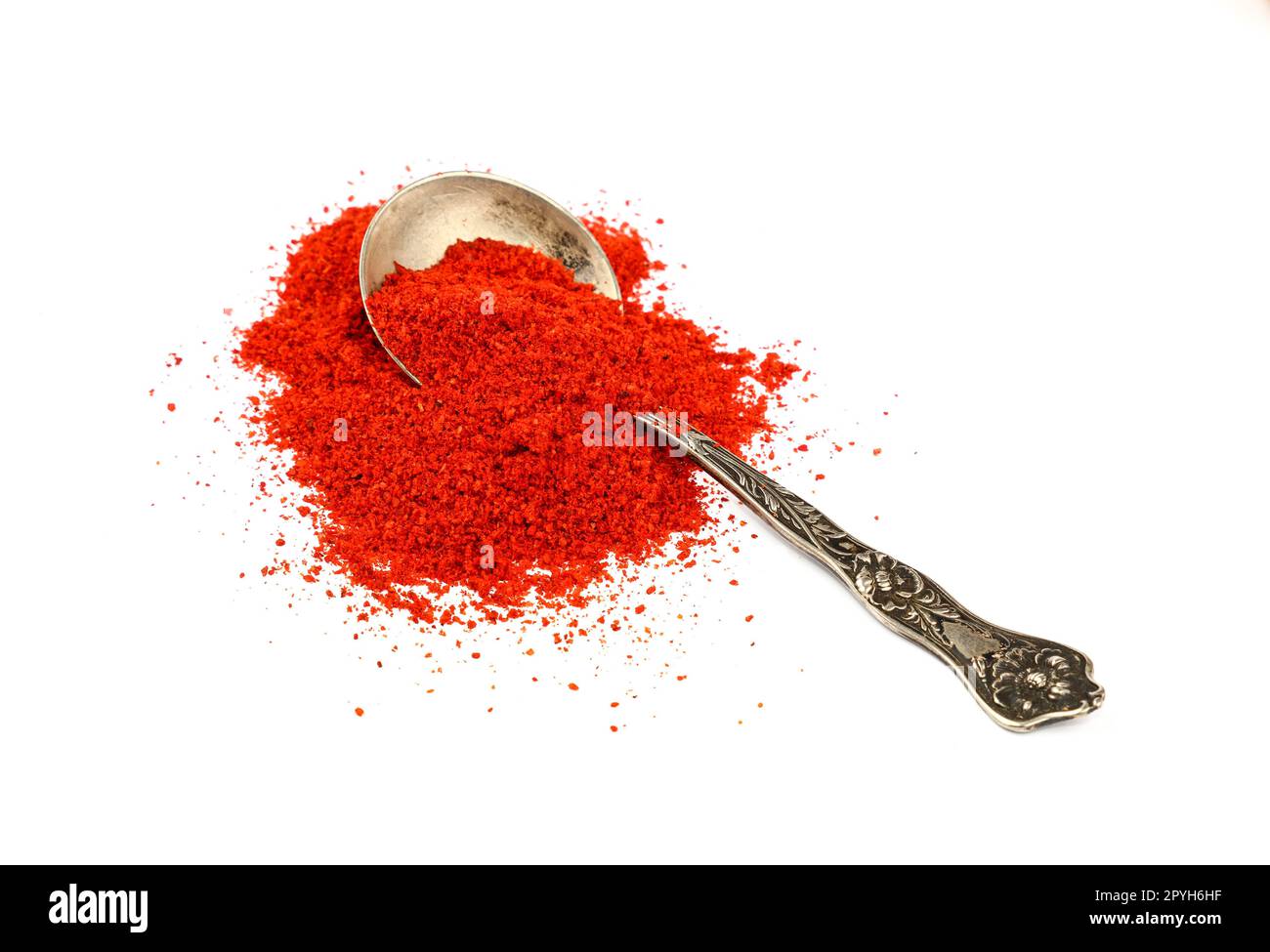 Metalllöffel voll mit roter, heißer Chili-Pfeffer Stockfoto