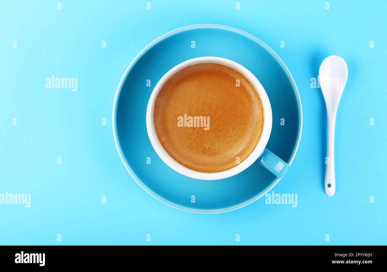 Volle Tasse Espresso auf blauem Papier Stockfoto