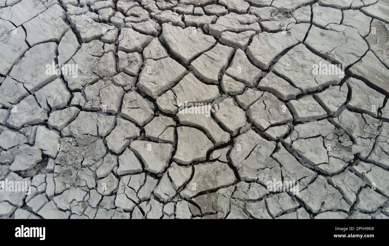 Gerissene Tonböden infolge von Dürre und Flusswasserverschwendung. Stockfoto