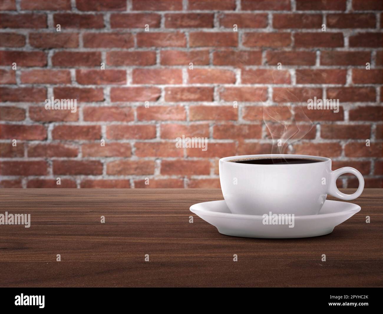 Heiße Kaffeetasse auf Holztheke, roter Backsteinhintergrund Stockfoto