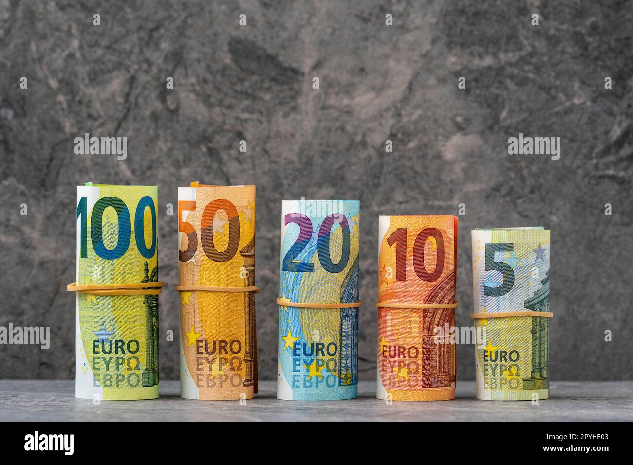 Geradlinig gerollte hundert, fünfzig, zwanzig, zehn und fünf Euro-Banknoten in Papierform Stockfoto
