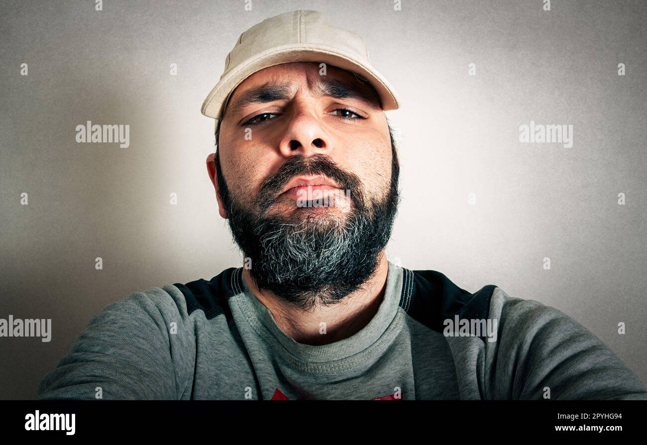 Lustiger Mann mit dem Bart, der Ausdrücke macht Stockfoto