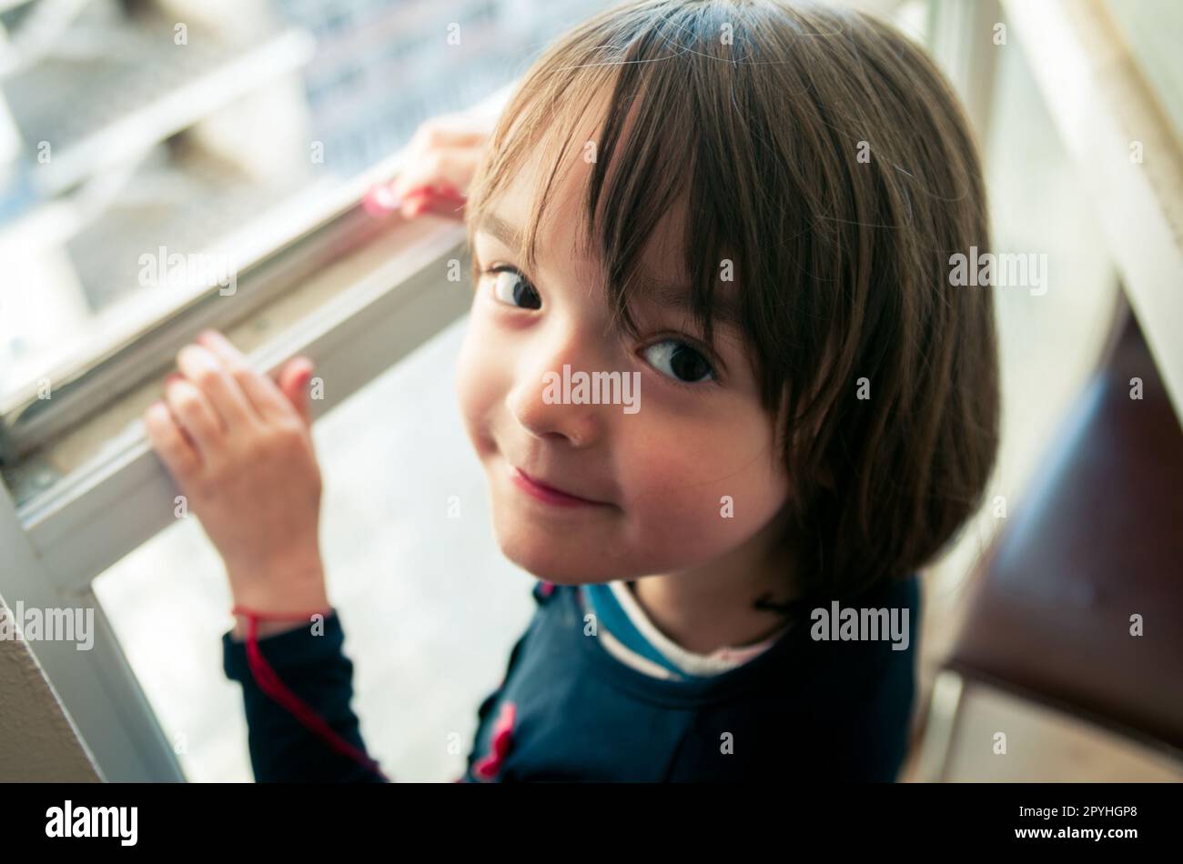 Kleines Mädchen schaut aus dem Fenster Stockfoto