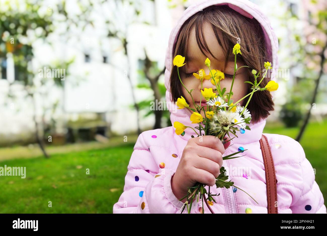 Kleines Mädchen draußen mit den Blumen Stockfoto