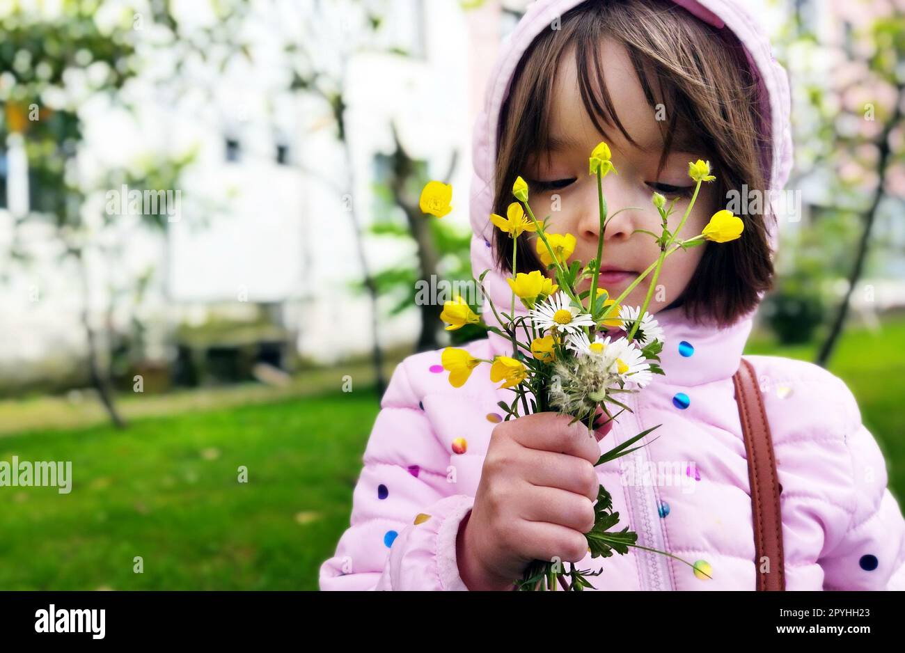 Kleines Mädchen draußen mit den Blumen Stockfoto