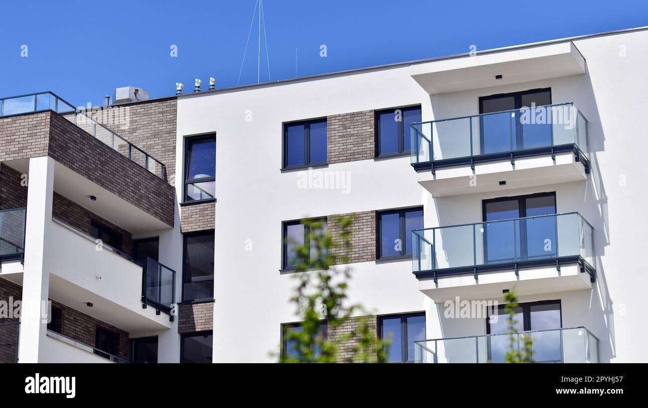 Ökologie und umweltfreundliches Leben in der Stadt, städtisches Umweltkonzept. Modernes Apartmentgebäude mit grünen Bäumen. Ökologische Wohnarchitektur. Stockfoto