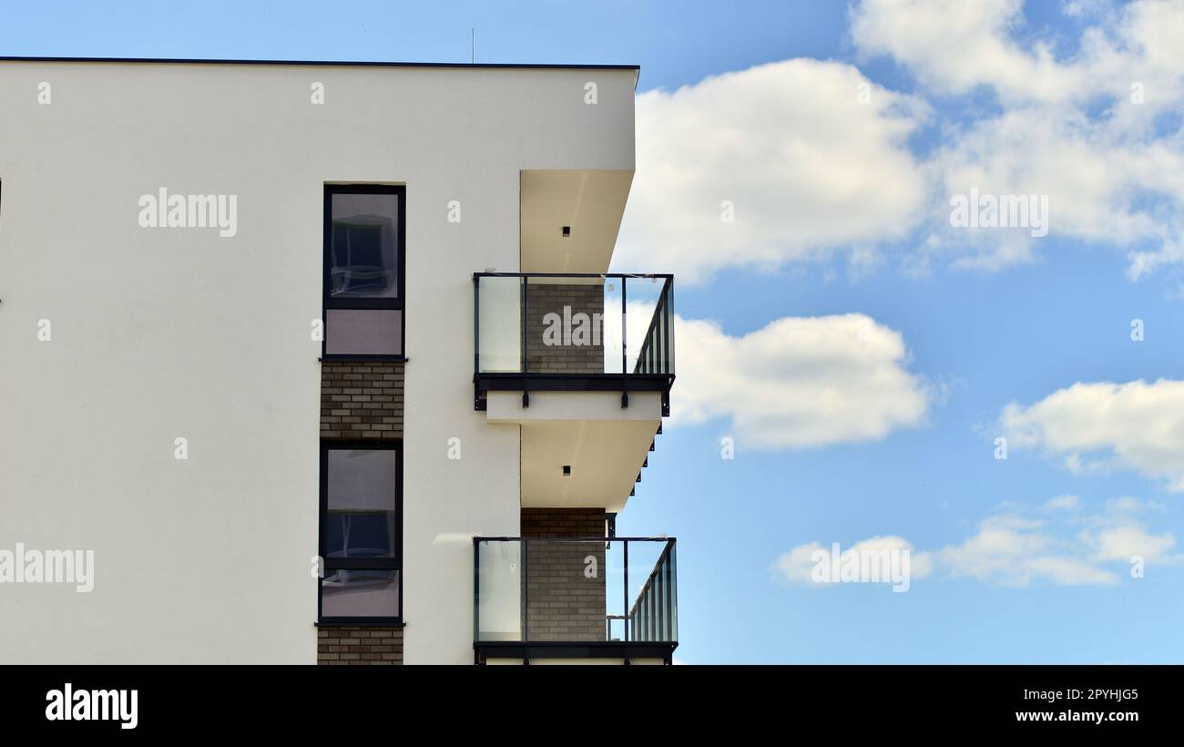 Moderne Appartementgebäude an einem sonnigen Tag mit blauem Himmel. Fassade eines modernen Apartmentgebäudes. Zeitgenössisches Wohngebäude von außen Stockfoto