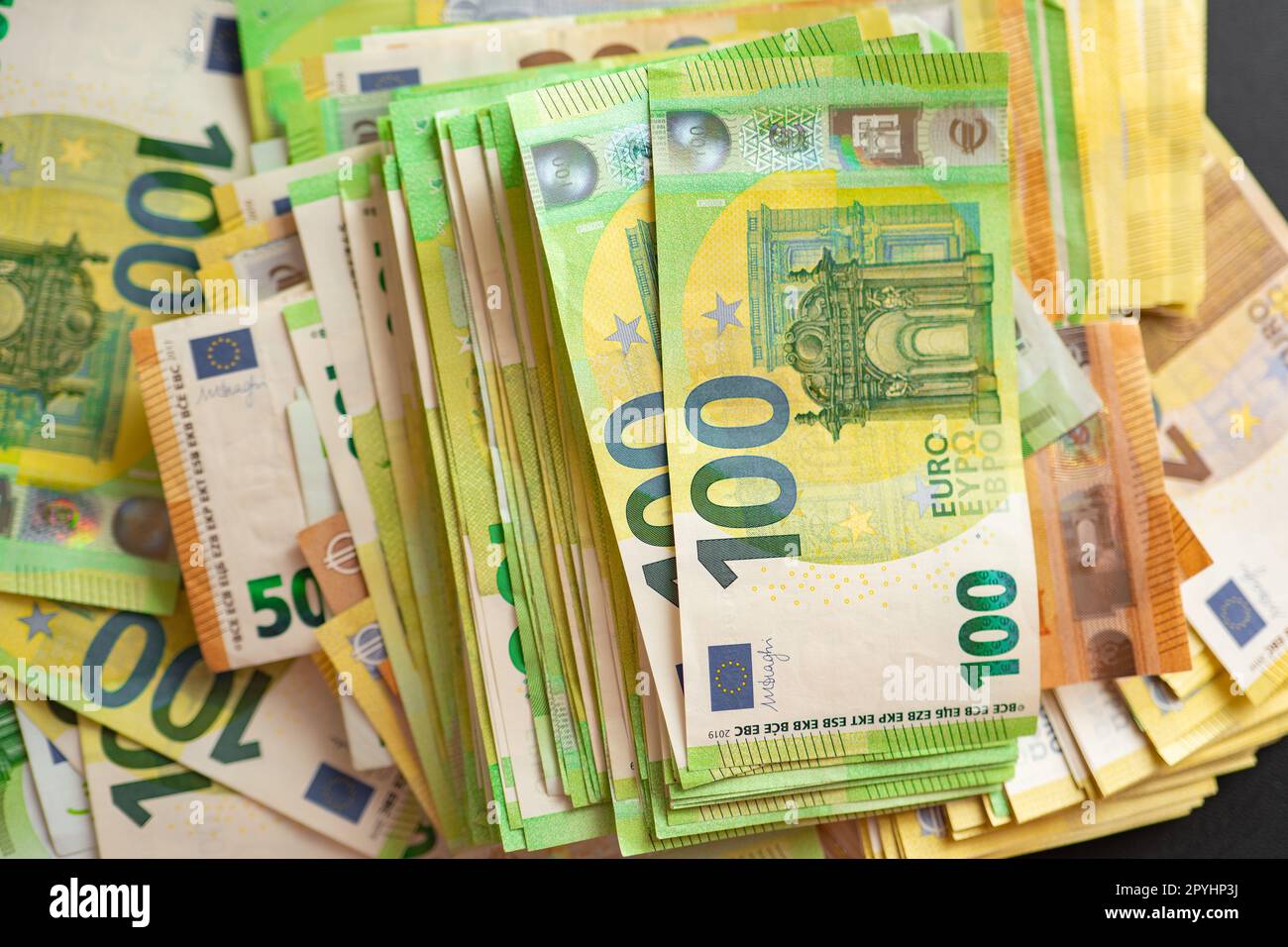 eine packung Geld. Geld zählt. Einhundertfünfzig Euro-Banknoten auf dem schwarzen Tisch. Euro-Banknoten zählen. Ausgaben und Einkommen in Europa Stockfotografie