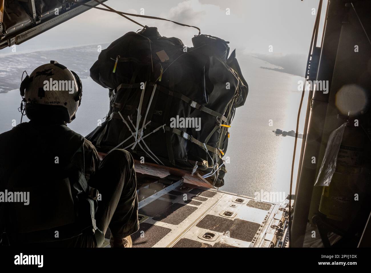 USA Marinekorps, Sergeant Anthony I.. White, ein Lastmaster mit Marine Aerial Tanken Transport Squadron (VMGR) 252, entlässt Fracht von einem KC-130J Hercules während eines Fluges über Havoc, Florida, am 26. April 2023. VMGR-252 nahm an der jährlichen Emerald-Warrior-Übung 16. Teil, einer Feldübung, die Spezialeinsatzkräfte, konventionelle Truppenstellungskräfte, internationale Partnerkräfte und interinstitutionelle Elemente vorbereiten soll, um sie in ein komplexes und sich entwickelndes Sicherheitsumfeld zu integrieren. VMGR-252 ist eine Untereinheit von 2. Marine Aircraft Wing, dem Luftkampfelement von II Marine Expediti Stockfoto