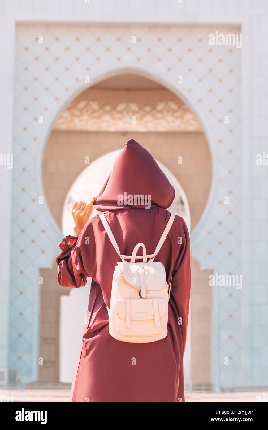 Die Pracht der Scheich-Zayid-Moschee wird noch verstärkt durch den Anblick eines touristischen Mädchens in Abaya, das durch seine Flure läuft. Stockfoto