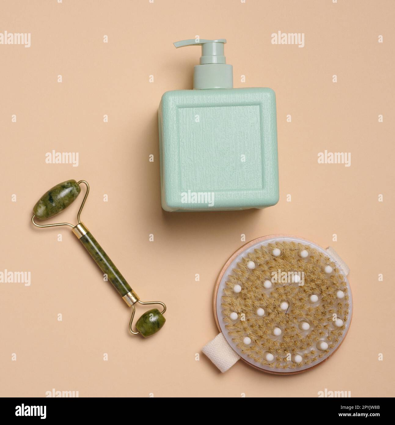 Kunststoffbehälter für flüssige Schönheitsprodukte, Holzbürste und Gesichtsmassagegerät aus Stein, Draufsicht Stockfoto