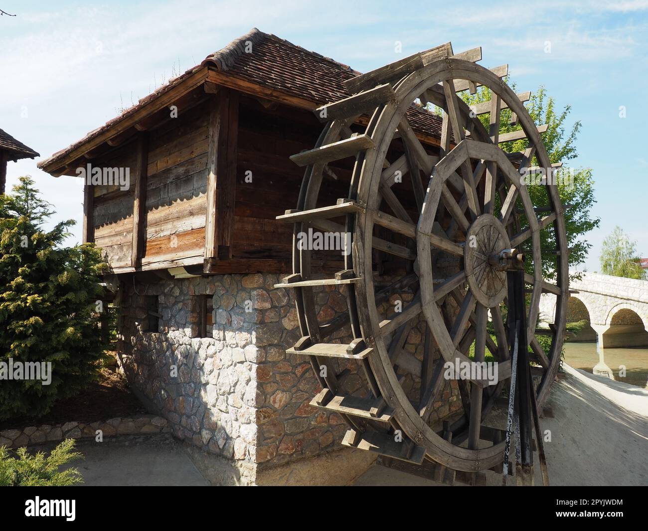 Wassermühle aus Holz Eine hydraulische Struktur, die Wasserkraft aus einem Wasserrad nutzt. Sinnvolle Arbeit mit einem Zahnradsatz Stockfoto