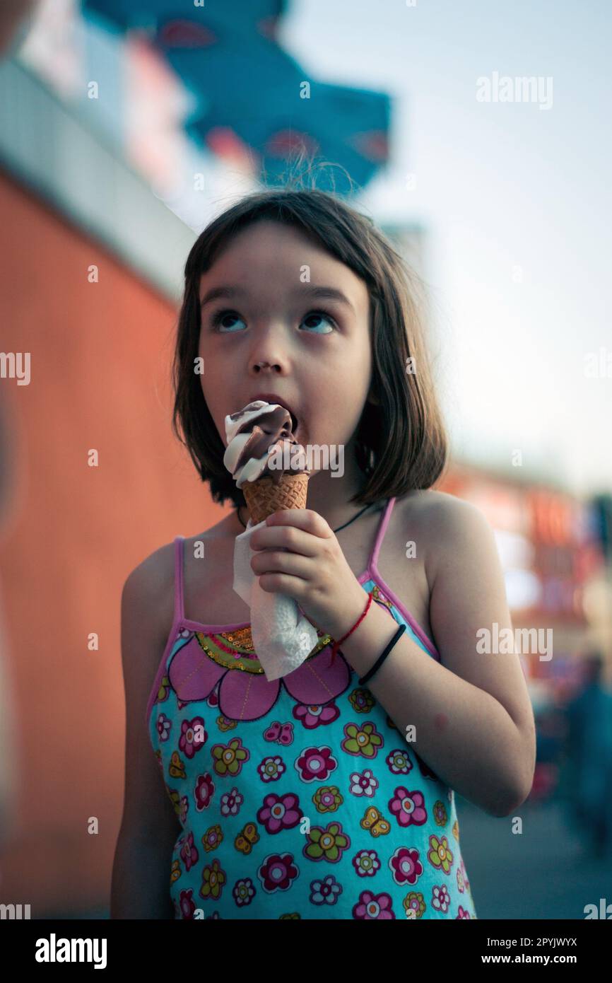 Kleines Mädchen, das draußen Eis isst Stockfoto