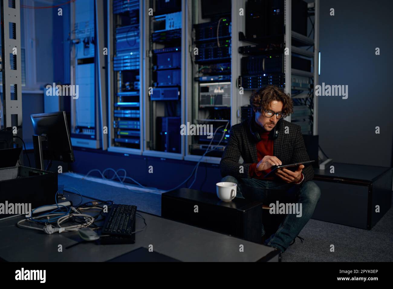 Männlicher IT-Techniker, der im Serverraum mit einem Tablet arbeitet Stockfoto
