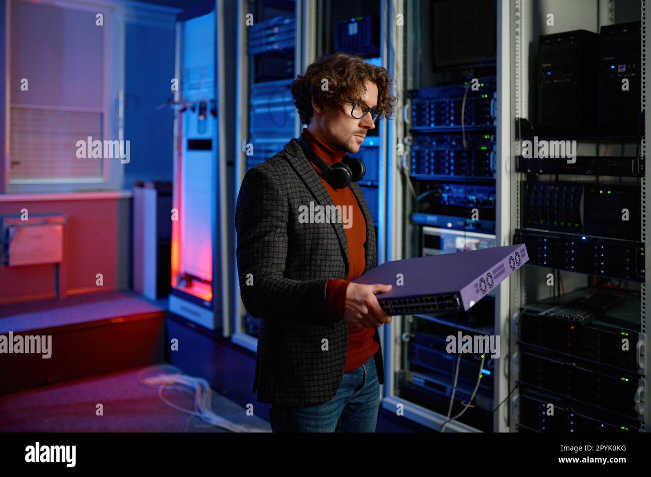 Porträt eines IT-Spezialisten, der im Serverraum Hardware in der Hand hält Stockfoto