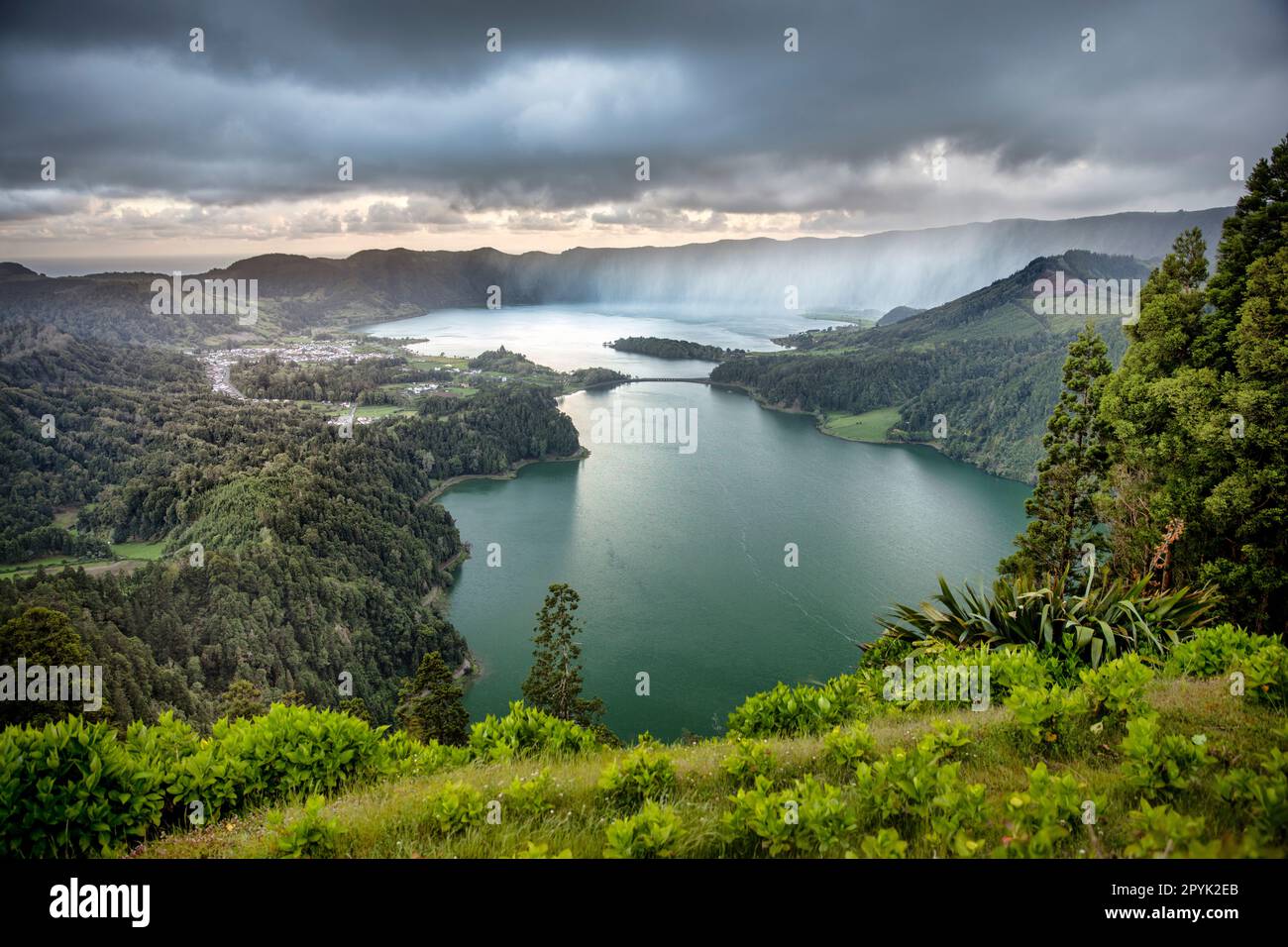 Portugal, Azoren, Insel Sao Miguel, Sete Cidades. Die blauen und grünen Zwillingsseen vom Aussichtspunkt Vista do Rei. Sonnenaufgang. Regen. Antenne. Stockfoto