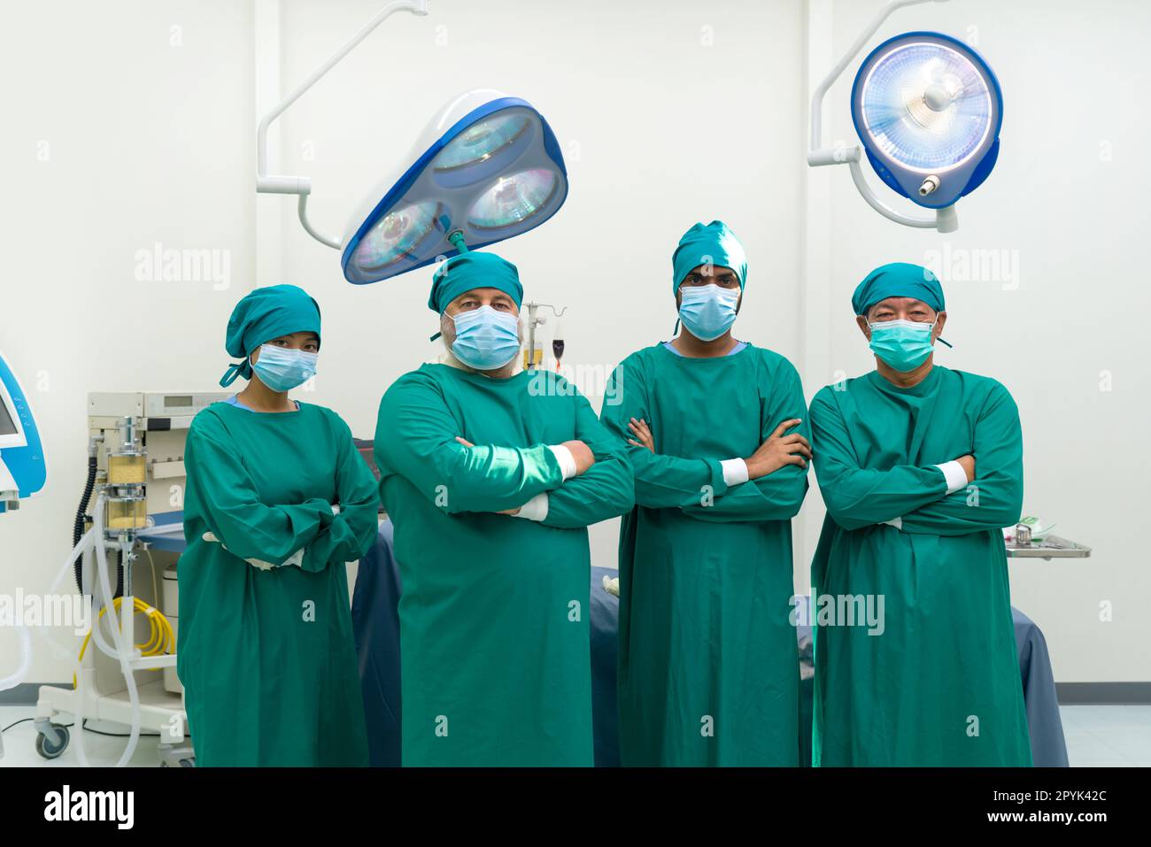 Chirurg und Krankenschwester im grünen Operationskittel stehen sicher mit gefaltetem Arm, bevor sie eine Operation im Operationssaal durchführen. Stockfoto