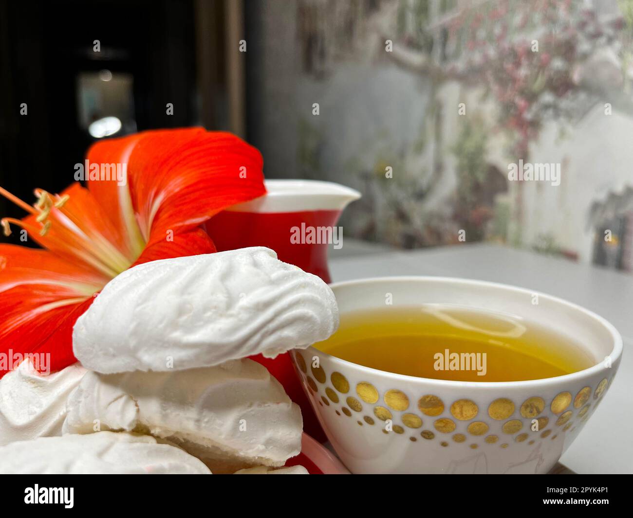 Ein paar Marshmallows auf einer Untertasse und eine Tasse duftenden Tee Stockfoto