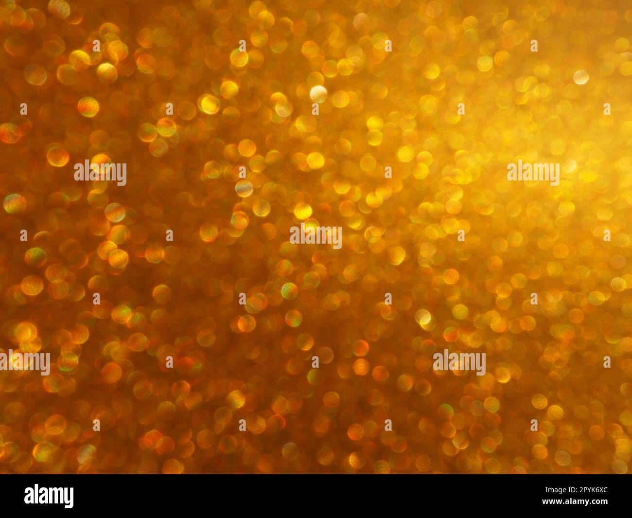 Bokeh-Licht aus Gold glitzert. Goldener, glitzernder Hintergrund. Glitzerndes Geschenkpapier mit Pailletten und Glitzern. Festliches goldenes Bokeh und Glitzer. Wunderschöner Hintergrund. Stockfoto