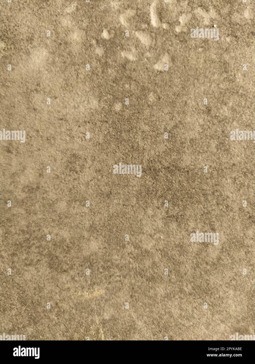 Die strukturierte Oberfläche einer Betonwand, Marmor oder hellen Steins mit dunklen Flecken. Abstrakter Hintergrund. Kreativer hellgrauer Hintergrund mit roten und braunen Moos-, Schmutz- und Staubstücken Stockfoto