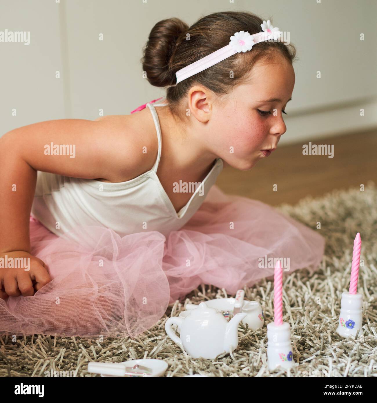 So mädchenhaft, wie es Mädchentum ist. Ein bezauberndes kleines Mädchen, das zu Hause eine Fantasieparty veranstaltet. Stockfoto