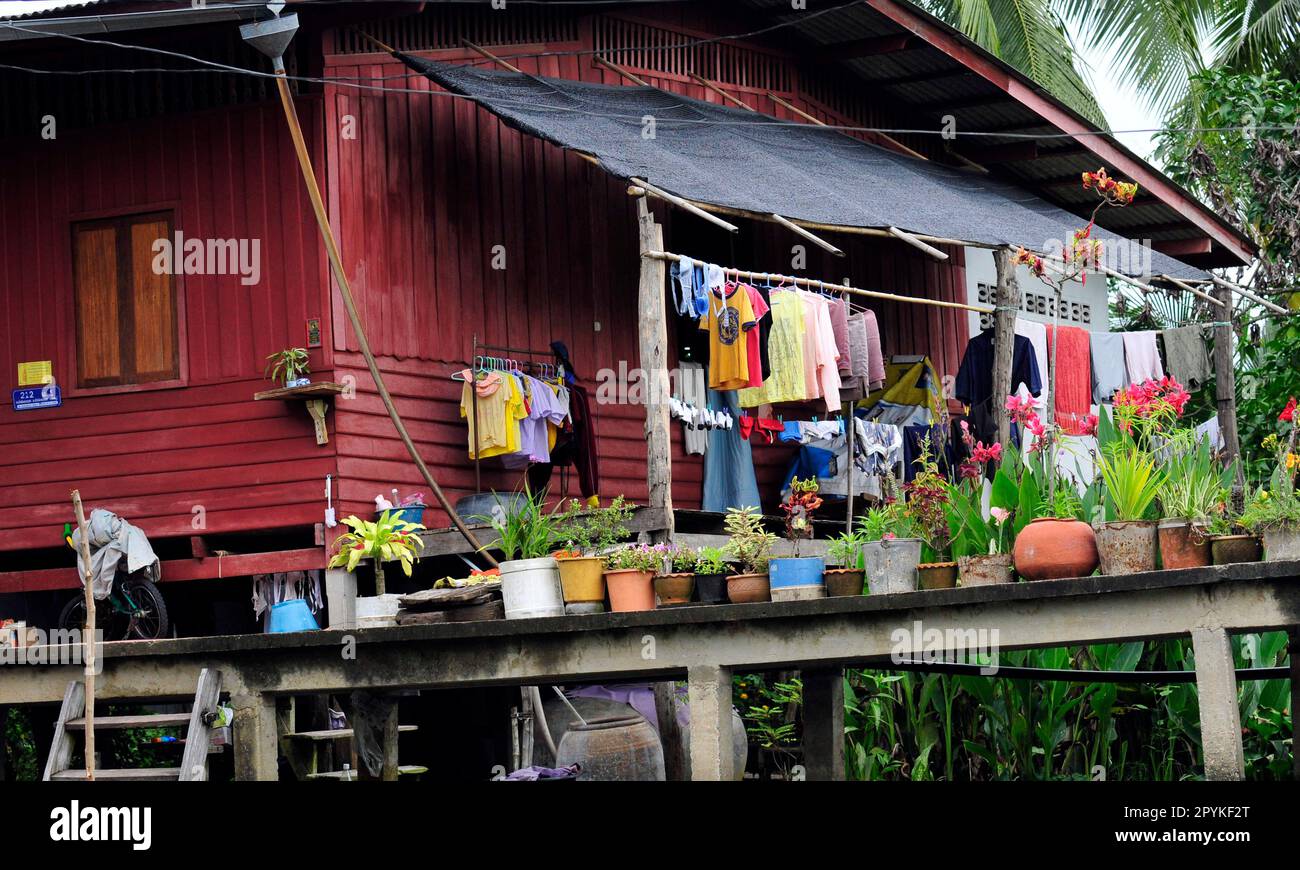 Ein Holzhaus am Ufer des Flusses auf dem schwimmenden Markt Amphawa in Thailand. Stockfoto Ein Holzhaus am Ufer des Flusses auf dem schwimmenden Markt Amphawa in Thailand. Stockfoto