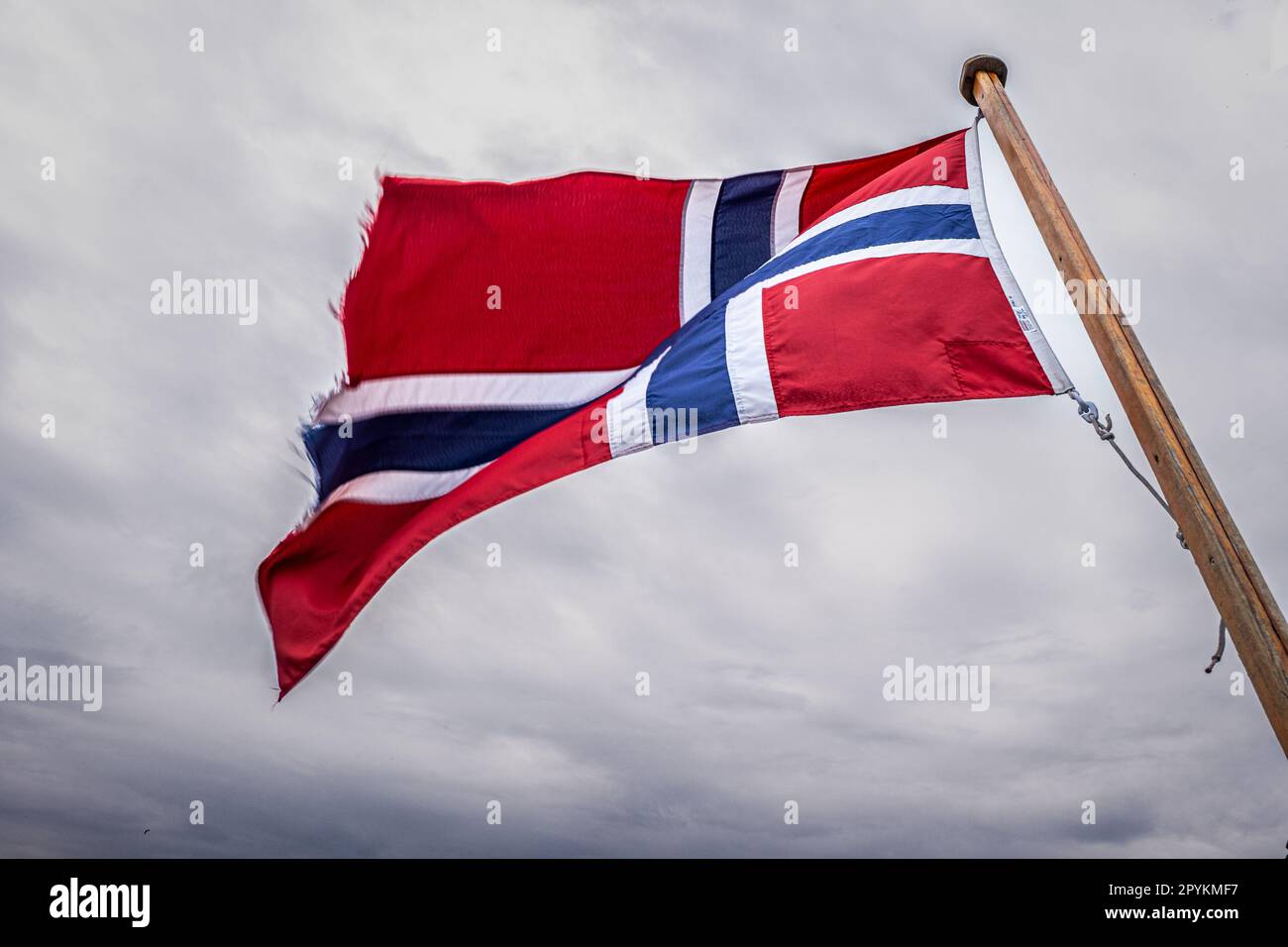 Die norwegische Flagge, die vom Fahnenstab eines Schoner-Segelboots im Hafen von Oslo aus fliegt. Stockfoto