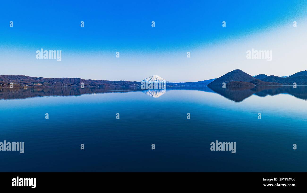 Die Reflexion der Berge im stillen Wasser des Toya-Sees Stockfoto