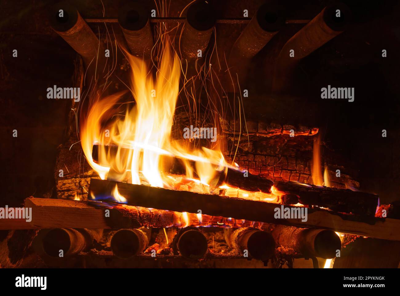 Eine intensive Nahaufnahme eines brennenden Feuers im Kamin, umgeben von feurigen Flammen und der Strahlungswärme des brennenden Holzes. Stockfoto
