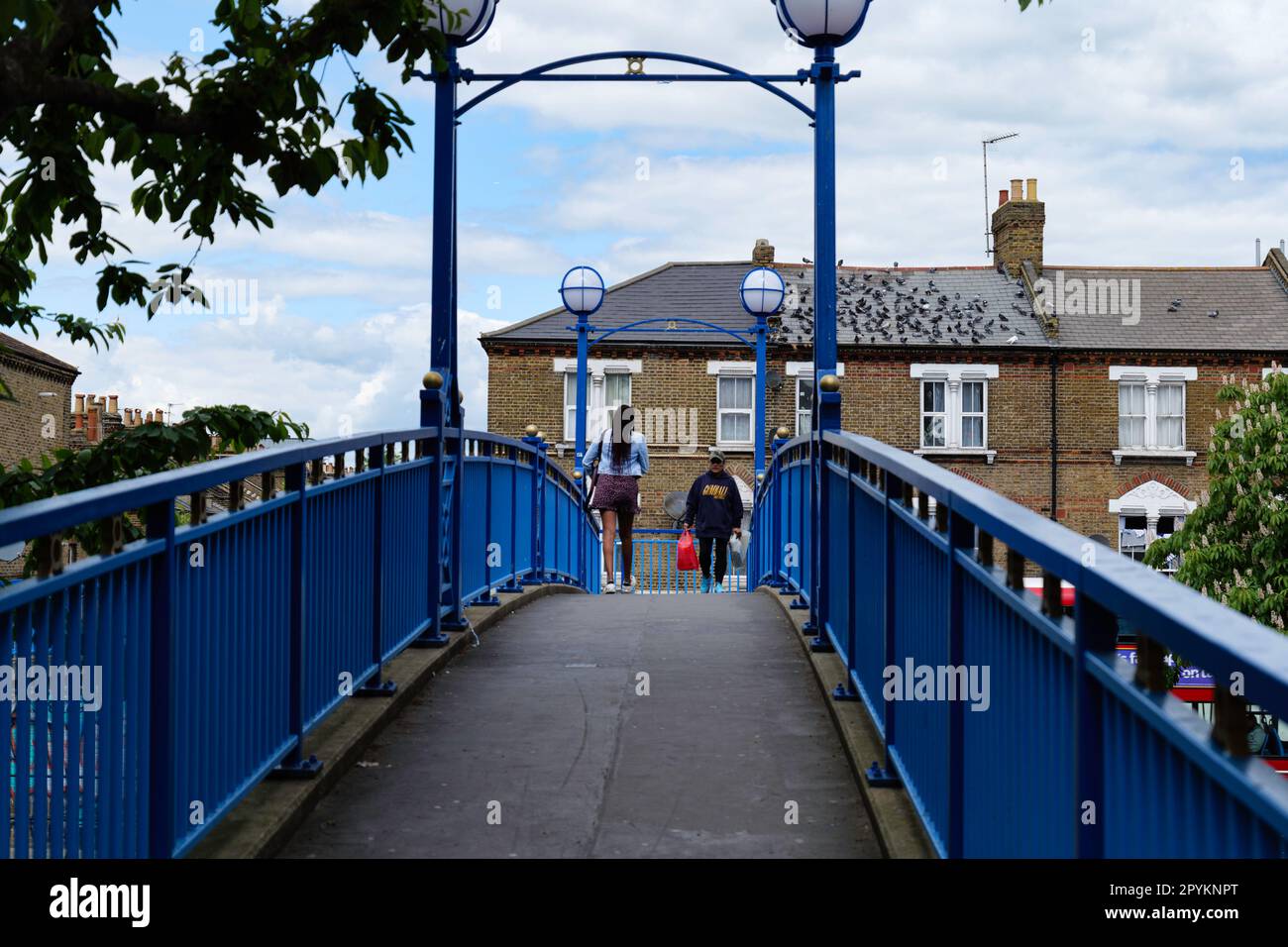 London - 05 21 2022 Uhr: Zwei Frauen überqueren die Fußgängerbrücke der Half Penny Steps über den Grand Union Canal in der Nähe der Wedlake Street Stockfoto