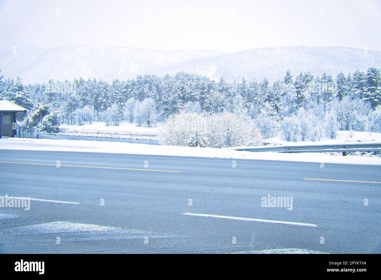 Winterlandschaft in Skandinavien. Mit schneebedeckten Bäumen auf einer Straße. Landschaftsfoto aus dem Norden Stockfoto