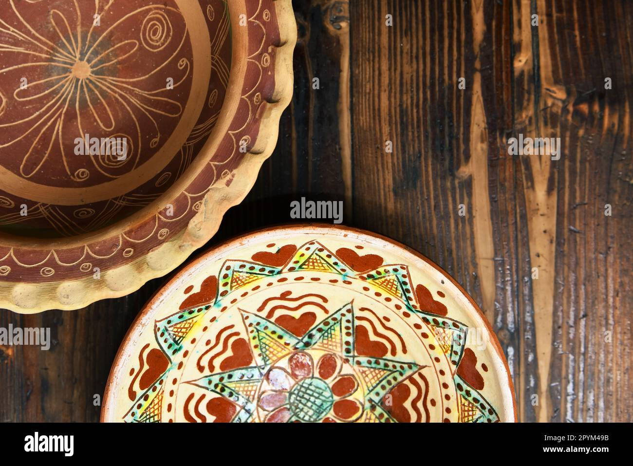Ukrainische Volkskeramik-Teller mit Blick von oben auf einem Holztisch Stockfoto
