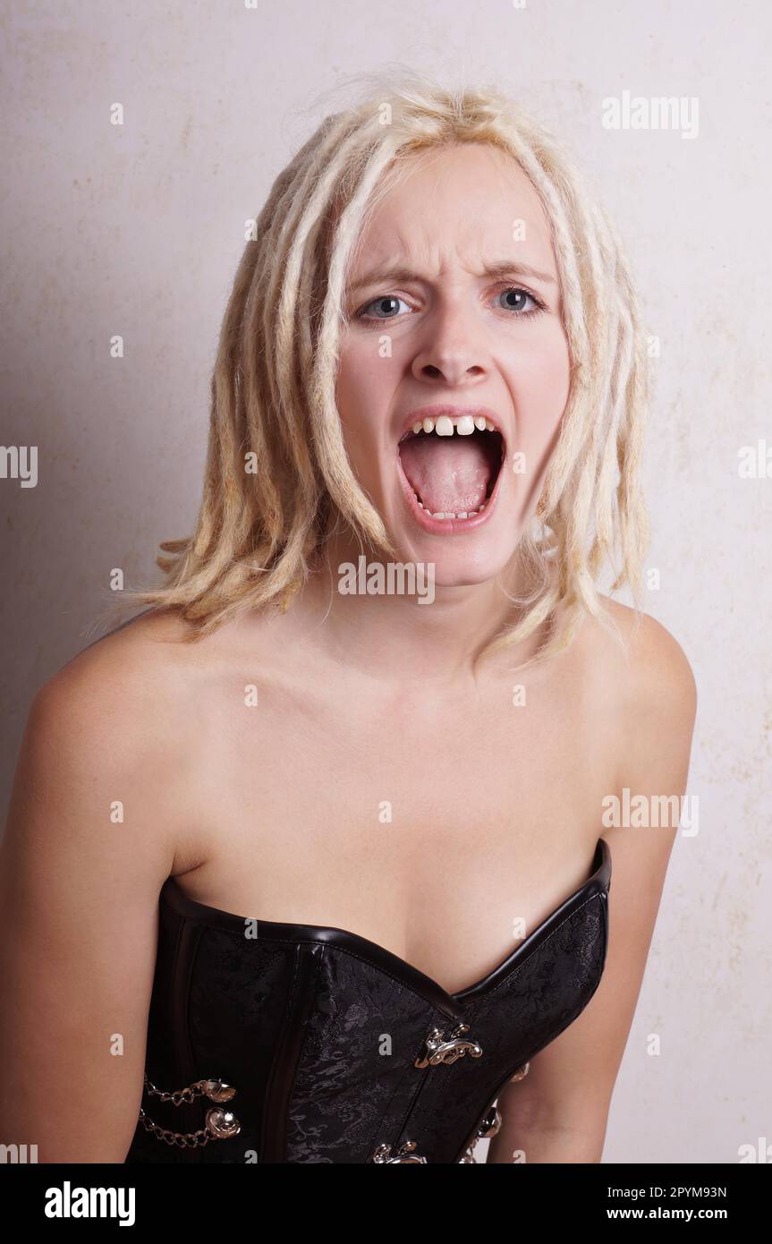 Schreien und schreien junge Frau mit blonden Dreadlocks in eine Raserei Stockfoto