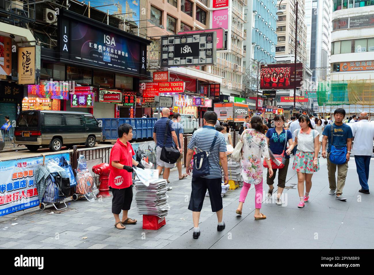 Frau verteilt Zeitungen an Passanten, Kowloon, Hongkong, China, Zeitungsverkäufer Stockfoto