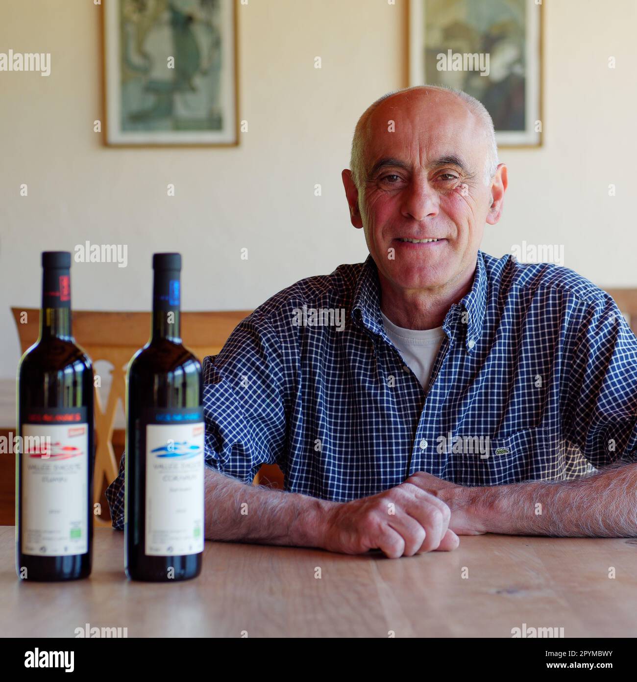 Eigentümer des Weinbergs Les Granges im Aosta-Tal, NW Italien, zusammen mit Flaschen Wein Stockfoto