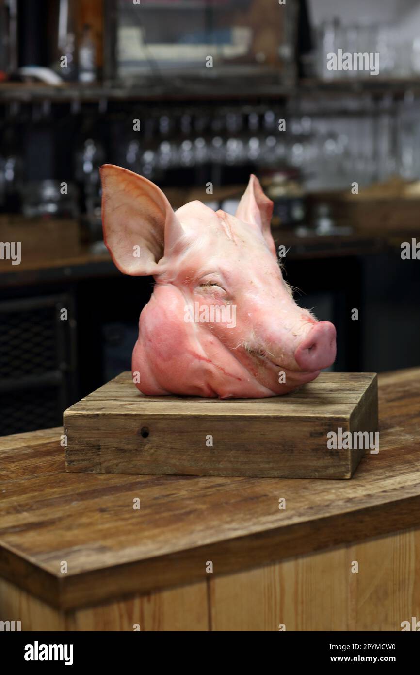 Schweinekopf auf Holzhacke. Schwein an einem Tag, eintägiger Metzgerkurs Stockfoto