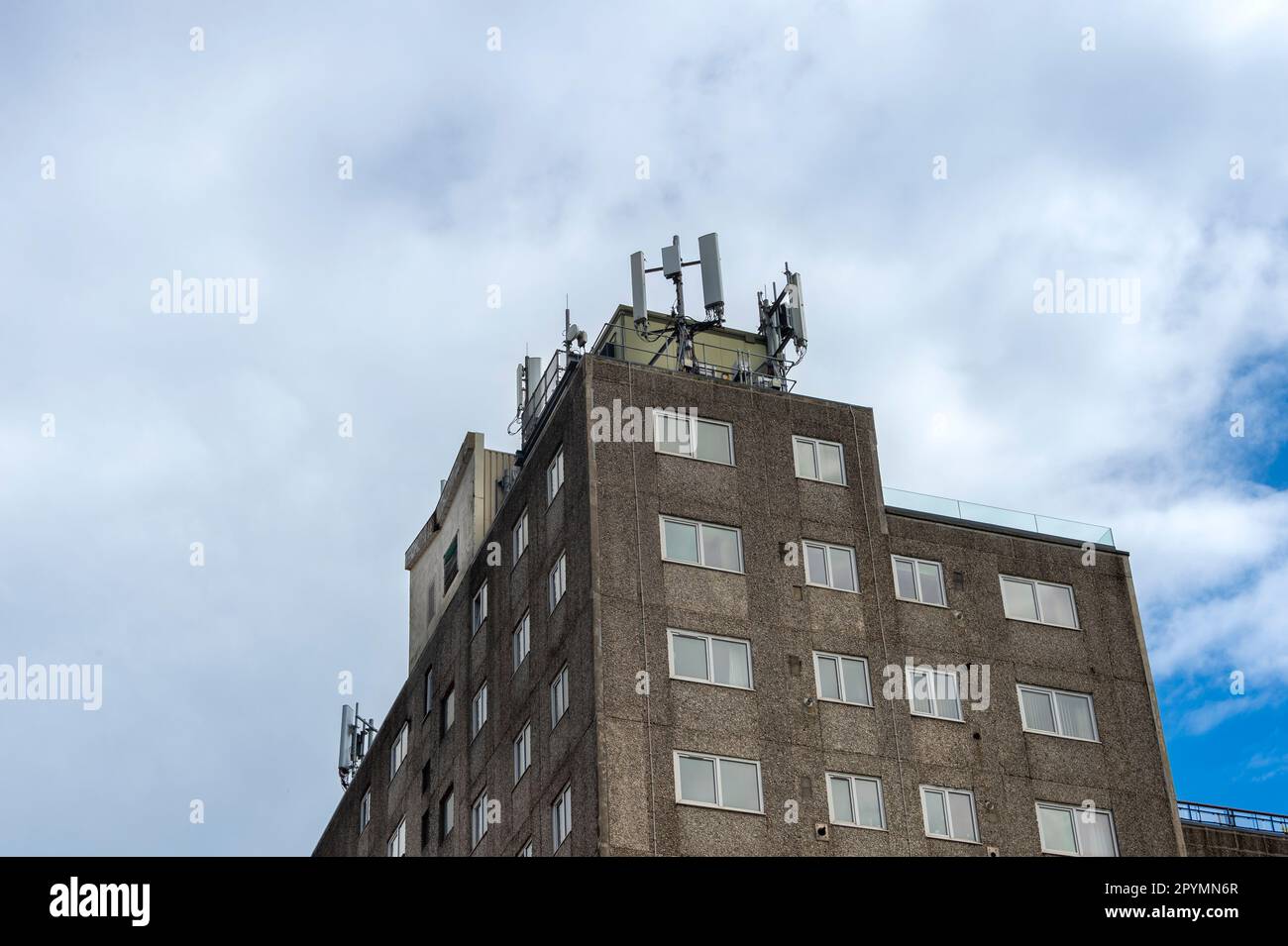 Apartmentblock mit GSM-Antennen auf dem Dach. Strahlungsgefahr. Stockfoto