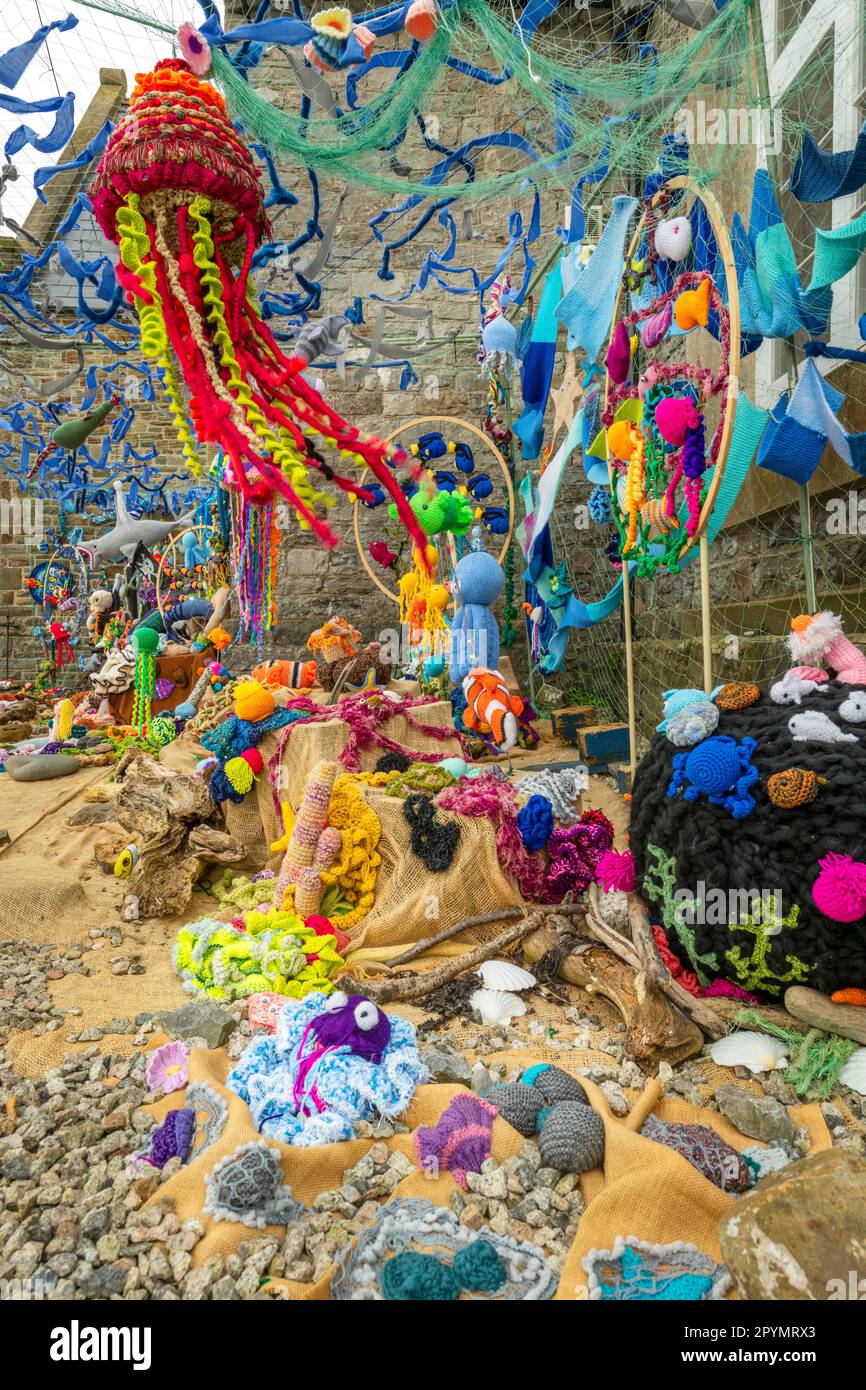 Donnerstag, 4. Mai 2023. Appledore, North Devon, England - an einem Tag mit Blusterei und Bewölkung an der Küste von Nord-Devon bringt die Appledore Knitters & Craft Community mit ihrem „Under the Sea“-Display vor dem Dorfsaal einen Farbtupfer ins Dorf. Einheimische Stricker verbrachten gemeinsam Hunderte von Stunden mit der Herstellung und Montage des erstaunlichen Herzstücks, das sich bei Besuchern und Dorfbewohnern gleichermaßen als beliebt erwiesen hat. Kredit: Terry Mathews/Alamy Live News Stockfoto