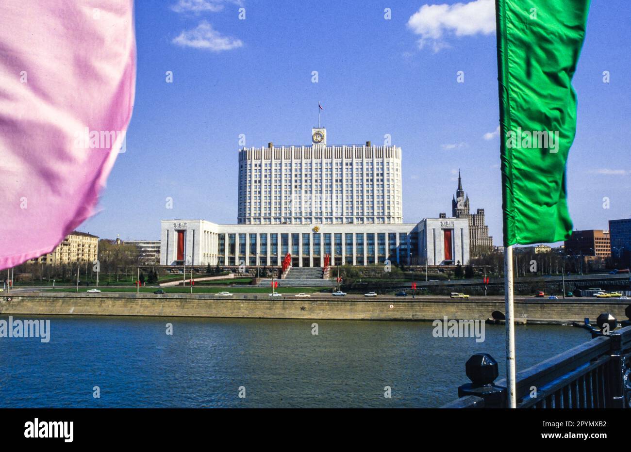 1988: Das Haus der Sowjets von Russland, kurz vor dem Maitag 1988. Das Gebäude wurde nach dem Putsch im August 1991 besser als das russische Weiße Haus bekannt und wurde 1993 während der russischen Verfassungskrise durch einen Panzerbrand schwer beschädigt, wurde aber seitdem wieder restauriert. Das barocke Gebäude im „Hochzeitstorten“-Stil im Hintergrund ist das Kudrinskaya Square Building, eine der so genannten „Sieben Schwestern“, die von Joseph Stalin als Teil eines Plans zur Modernisierung Moskaus unmittelbar nach dem Zweiten Weltkrieg in Auftrag gegeben wurde Eine weitere der Sieben Schwestern, das Hotel Ukraina, blickt auf das Weiße Haus auf der anderen Seite der Moskva. Stockfoto