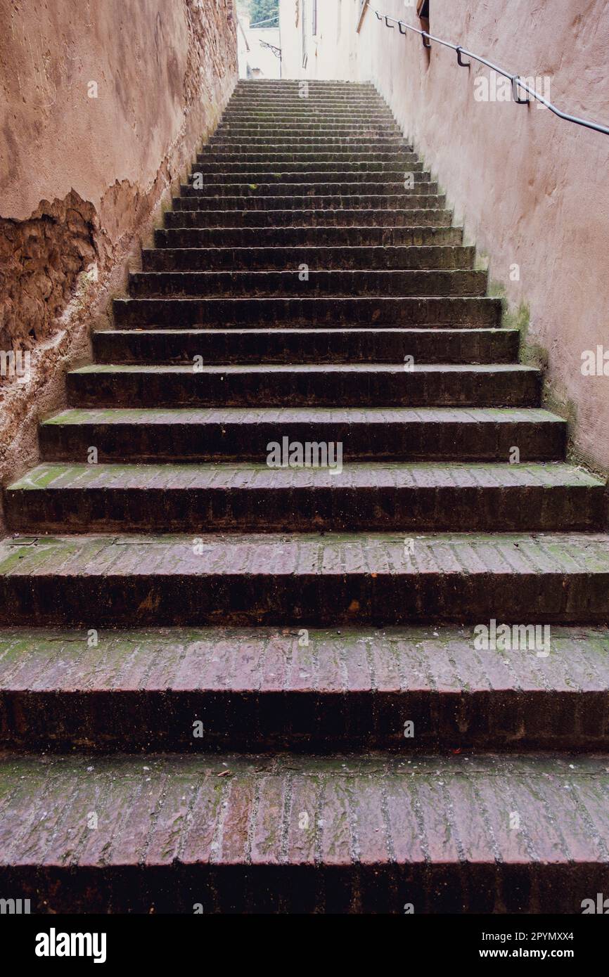 Alte Steintreppen in einer kleinen italienischen Stadt, verdorben und von vorbeigehenden Füßen getragen. Stockfoto