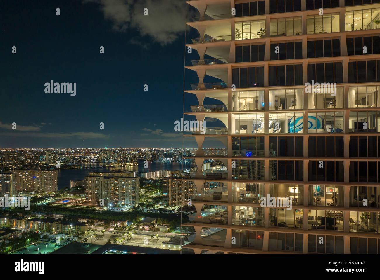 Ein Blick aus der Vogelperspektive auf den nächtlichen Hochhaus-Wolkenkratzer in der Sunny Isles Beach City in Florida, USA. Wohnungsbau im modernen amerikanischen Stadtgebiet. Stockfoto