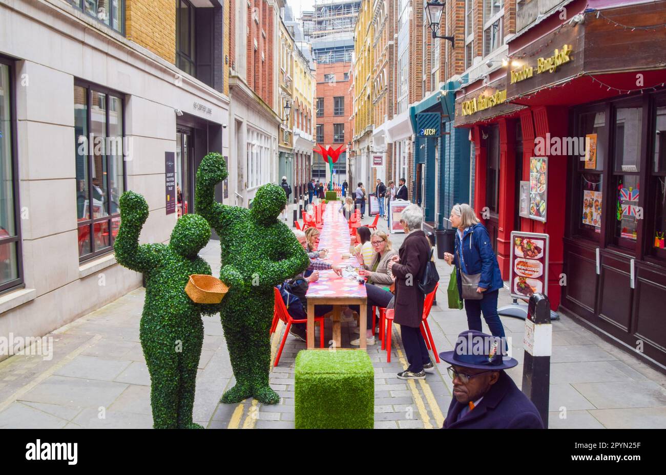 London, Großbritannien. 4. Mai 2023 Im Big Picnic im Fleet Street Quarter, einem langen Tisch in der Carter Lane, um die Krönung von König Karl III. Zu feiern, werden Besucher in Form von Pflanzen begrüßt. Hier können die Besucher ihr eigenes Mittagessen mitbringen und ein Picknick in der Stadt genießen. Kredit: Vuk Valcic/Alamy Live News Stockfoto