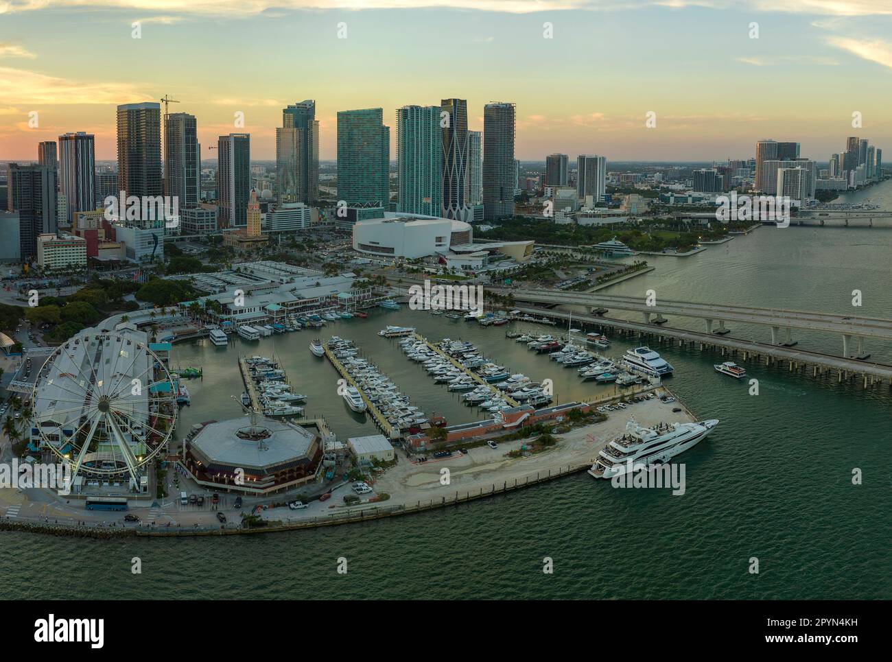 Hohe beleuchtete Wolkenkratzer von Brickell, dem Finanzzentrum der Stadt. Skyviews Miami Observation Wheel am Bayside Marketplace mit Reflexionen in Biscayn Stockfoto