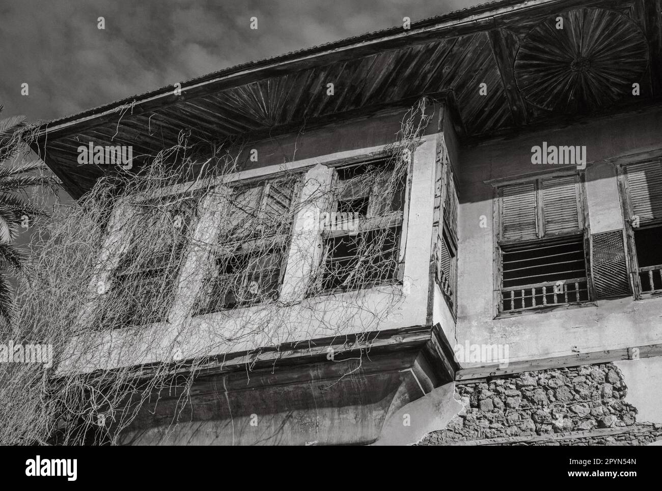 Ein verfallenes Haus im osmanischen Stil in der Altstadt von Antalya Kalechi enthüllt die verblasste Pracht vergangener Zeiten. Das überhängende Dach und die hölzernen Fensterläden Illu Stockfoto