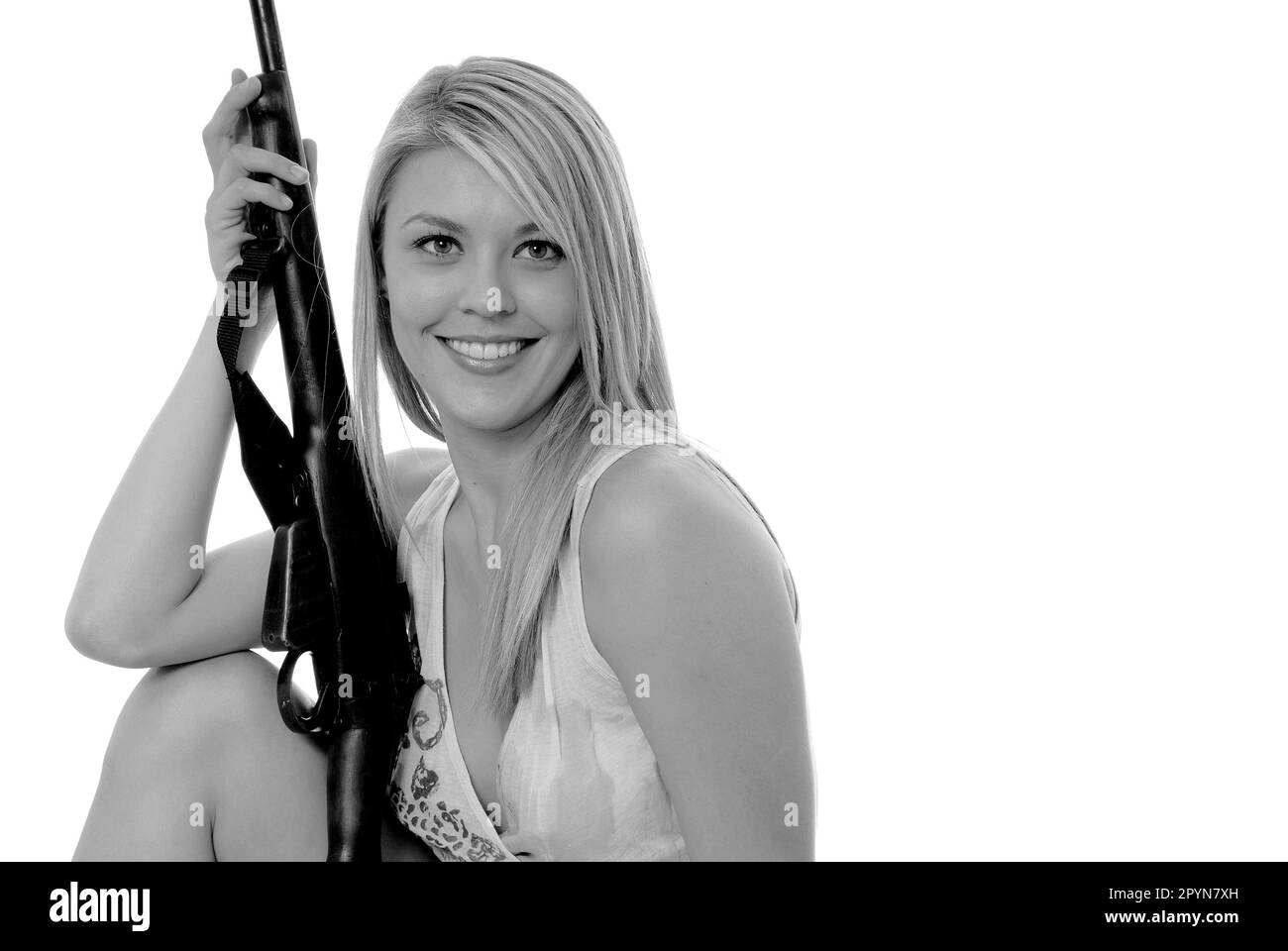 Hübsches, blondes Mädchen mit einem Gewehr Stockfoto