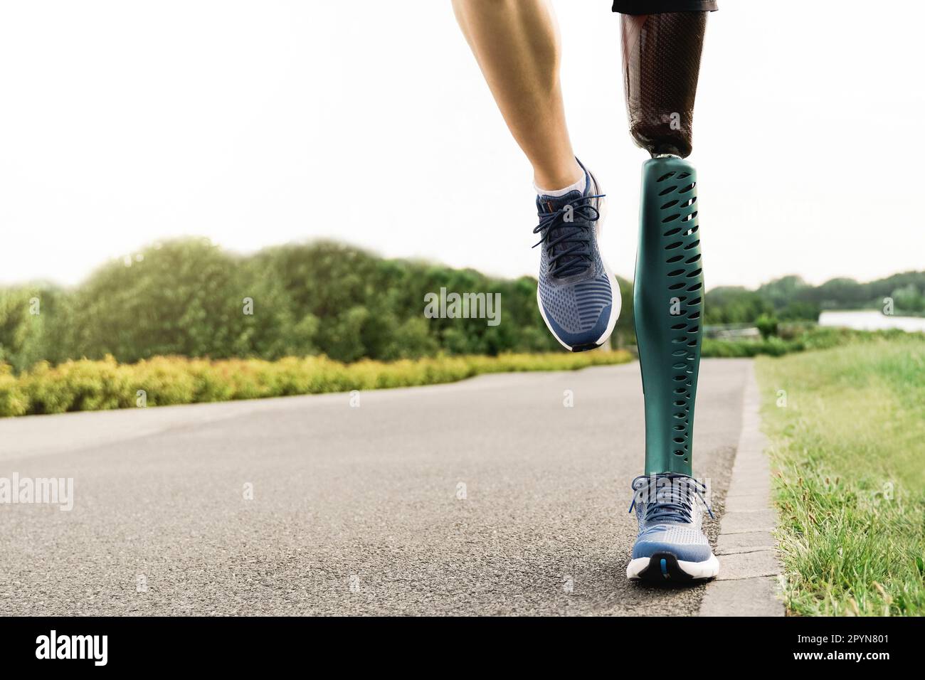 Sportler mit Beinprothese beim Laufen in Park City - körperliche Behinderung, gesundes Lebensstil-Konzept Stockfoto